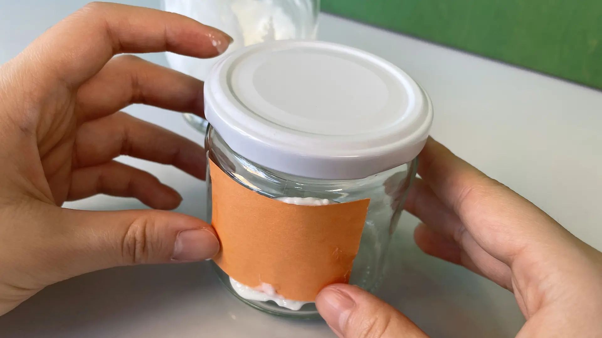 A piece of paper spread with casein glue is attached to the jam jar