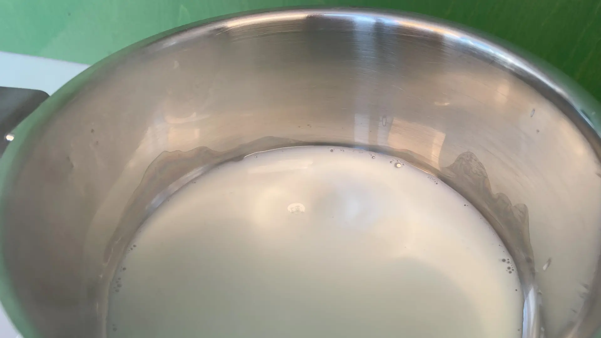 Saucepan containing milk on a hotplate