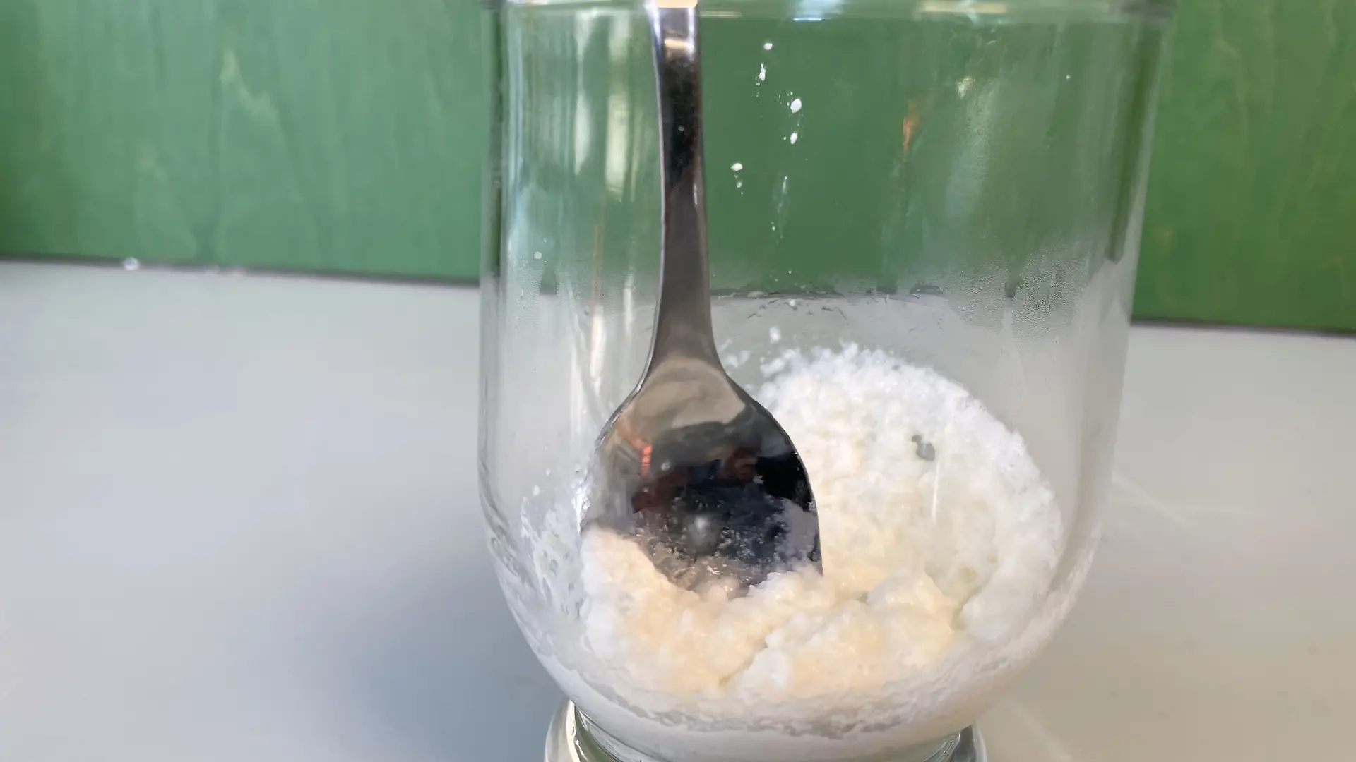 Glass with milk proteins, a little water and baking powder. Stir the mixture with a spoon.